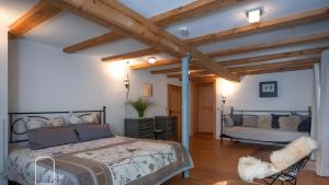 a bedroom with a bed in a room with wooden ceilings at Exklusives Gut Stohrerhof am See in Dießen am Ammersee