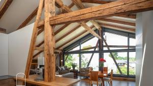a dining room with a large wooden ceiling and large windows at Exklusives Gut Stohrerhof am See in Dießen am Ammersee