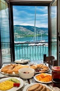 a table with plates of food and a view of the water at Vythos Occidens in Plataria