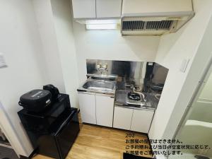 a small kitchen with a sink and a sink at SnowMapleHouse川口 in Kawaguchi