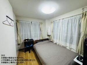 a bedroom with a bed and a desk and a window at SnowMapleHouse川口 in Kawaguchi