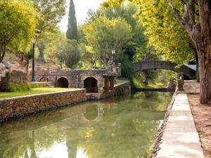a stone bridge over a river with trees and water at Casa D' Familia in Alte