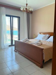 a bedroom with a large bed with towels on it at Vythos Occidens in Plataria