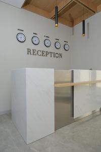 a reception area with clocks on a wall at GAIA Hostel in Türkistan