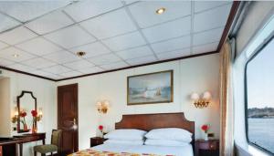 a bedroom with a large bed and a window at Sun Nile Cruise in Aswan