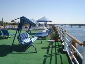 a group of chairs and tables on a deck next to the water at Sun Nile Cruise in Aswan