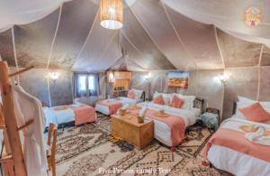 a bedroom with three beds in a tent at Majestic Dunes Luxury Camp in Merzouga +87 photos