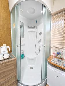 a shower with a glass door in a bathroom at Lee Ryokan Tokyo in Tokyo +16 photos