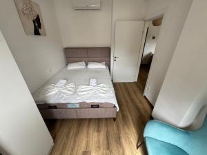 a small bedroom with a bed and a blue chair at Florida Apartments with PARKING in Dobra Voda