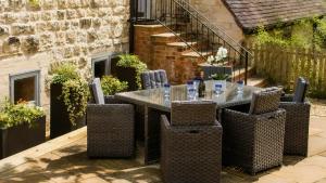 an outdoor table and chairs in a courtyard with a building at The Hayloft in Winchcombe +16 photos