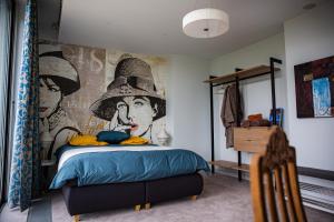 a bedroom with a mural of a woman wearing a hat at Villa Bianca in Dalhem