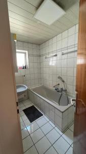 a white bathroom with a tub and a sink at Monteurzimmer Ringingen in Erbach +186 photos