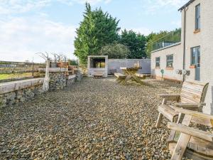 a patio with a picnic table and benches in front of a building at North Plain Barn in Bowness-on-Solway