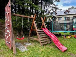 a playground with a slide and a rock wall at Chalupa U Potoka in Josefŭv Dŭl