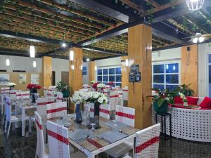 a dining room with white tables and white chairs at Jade Resort - Bauang, La Union in Bauang