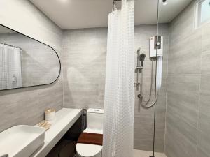 a bathroom with a shower with a toilet and a sink at Ranana Bangkok in Bangkok +26 photos