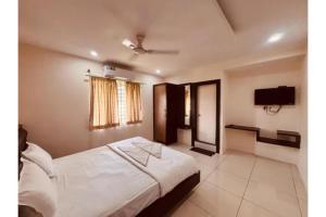 a bedroom with a bed and a flat screen tv at FabHotel Udupi in Mysore