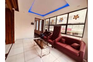 a man sitting on a couch in a room at FabHotel Udupi in Mysore +15 photos