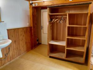a bathroom with a sink and a closet with shelves at Horská chata U Pekařů in Pec pod Sněžkou