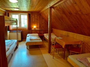 a room with two beds and a table in a cabin at Horská chata U Pekařů in Pec pod Sněžkou