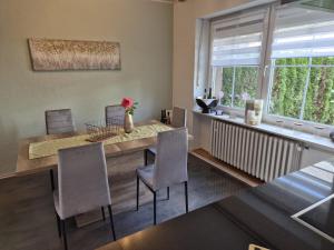 una sala da pranzo con tavolo e sedie e una finestra di House Eifelglück a Großlittgen