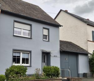 una casa bianca con un garage grigio di House Eifelglück a Großlittgen