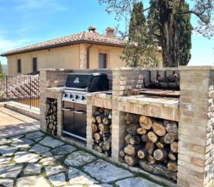 a outdoor kitchen with a stove and a pile of logs at Podere San Pietro in Cetona