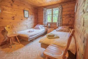 a bedroom with two beds in a log cabin at Cosy Chalet in Brig-Glis in Glis