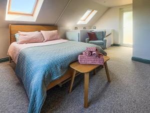 a bedroom with a large bed and a chair at Bay Tree in Sturminster Newton +6 photos