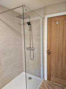 a shower with a glass door in a bathroom at Old Sun Inn in Haworth +44 photos