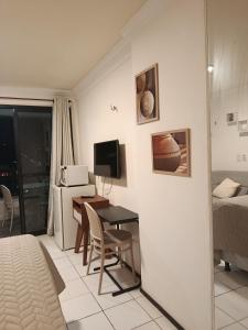a room with a bed and a desk with a computer at Oceanview Apart Residence in Natal