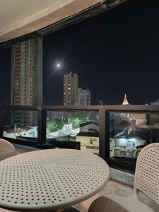 a table and chairs on a balcony at night at Oceanview Apart Residence in Natal