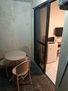 a room with a table and chairs and a refrigerator at Oceanview Apart Residence in Natal