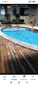 two people swimming in a large swimming pool at Oceanview Apart Residence in Natal