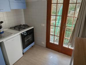 a kitchen with a stove top oven next to a window at Affittacamere Pietra Lucente in Riomaggiore