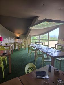 a restaurant with tables and chairs and a large window at Les Portes d'Apcher in Saint-Chély-dʼApcher