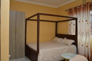 a bedroom with a canopy bed with white sheets at Maria VillaSTUDIO2 in Voi
