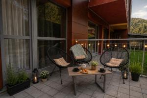 eine Terrasse mit drei Stühlen und einem Tisch auf einem Balkon in der Unterkunft Wise Nest Studio with pool and spa in Sinaia
