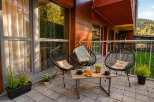 zwei Stühle und ein Tisch auf einem Balkon in der Unterkunft Wise Nest Studio with pool and spa in Sinaia