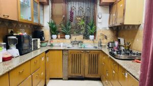 a kitchen with wooden cabinets and a sink at Dr Balis Bliss Homestay in New Delhi
