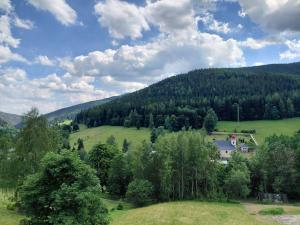a green hill with a house in the middle of a field at Horská chata U Pekařů in Pec pod Sněžkou