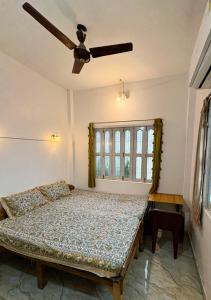 a bedroom with a bed and a ceiling fan at Om Rest House by Bunny Cafe Varanasi in Varanasi +60 photos