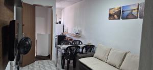 a living room with a couch and a table with chairs at Flat Centro Rota Cachoeira in Bonito +12 photos