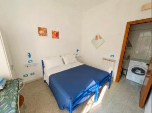 a bedroom with a blue bed and a washing machine at Affittacamere Pietra Lucente in Riomaggiore