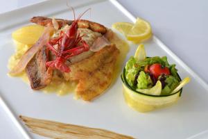 a plate of food with fish and a salad at Logis Hôtel Auberge de la Gabrière in Lingé