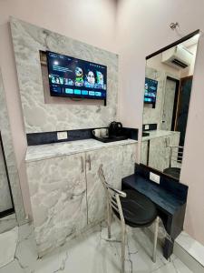a vanity with a chair and a television on a wall at Hotel Classy Comfort Business Family Hotel in Mumbai +39 photos