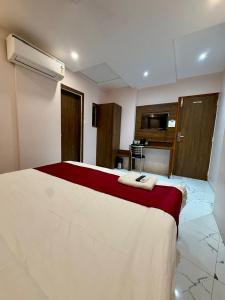a hotel room with a bed with a red and white blanket at Hotel Classy Comfort Business Family Hotel in Mumbai