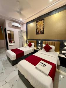 a hotel room with two beds with red pillows at Hotel Classy Comfort Business Family Hotel in Mumbai
