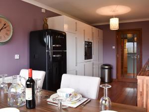 a kitchen with a wooden table with a black refrigerator at Cushendall House in Torcastle
