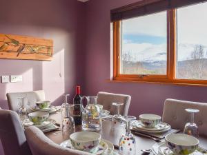 a dining room table with chairs and a window at Cushendall House in Torcastle